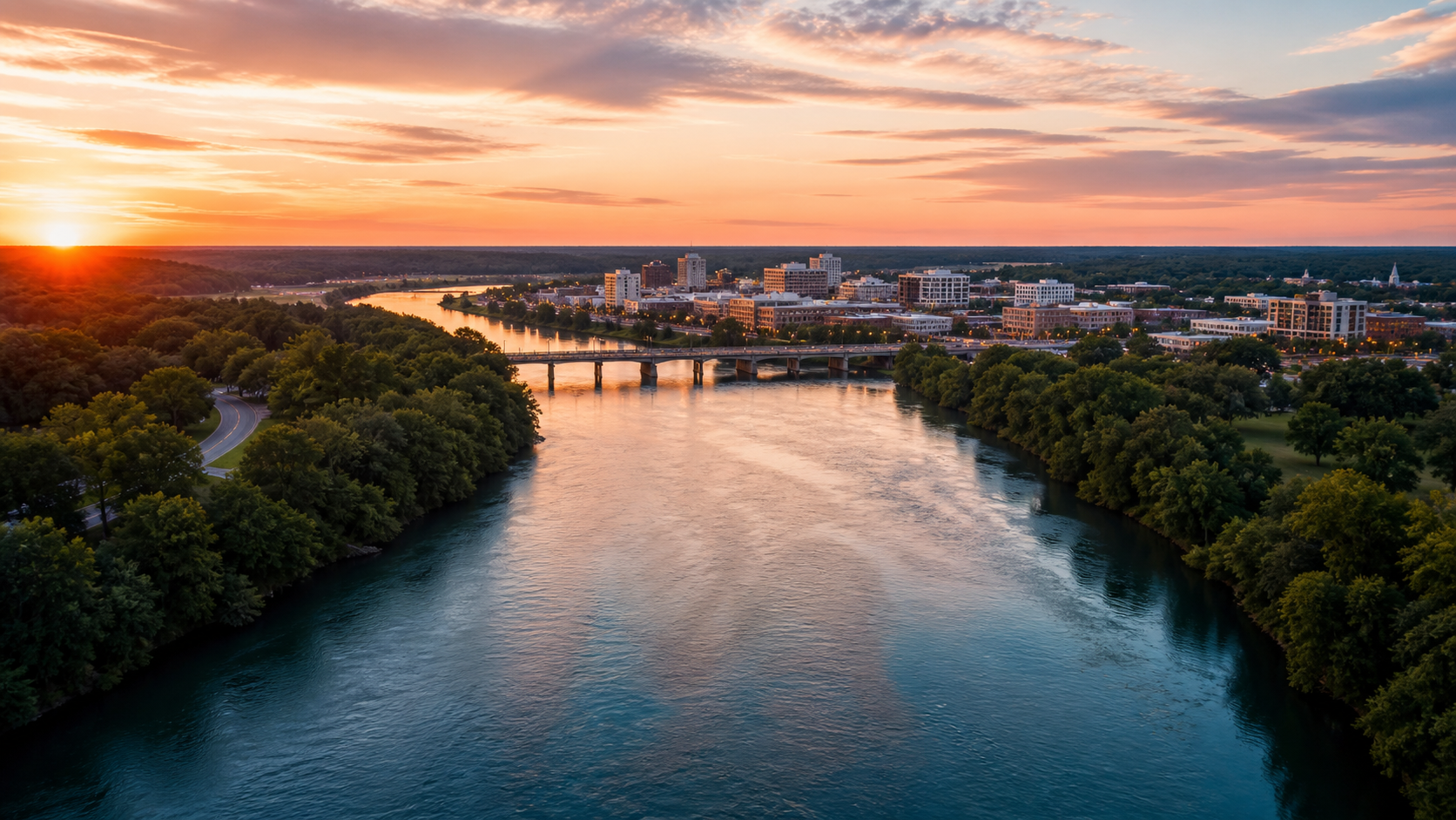 Illustrative cinematic aerial video frame showing a river, bridge, and South Carolina cityscape
